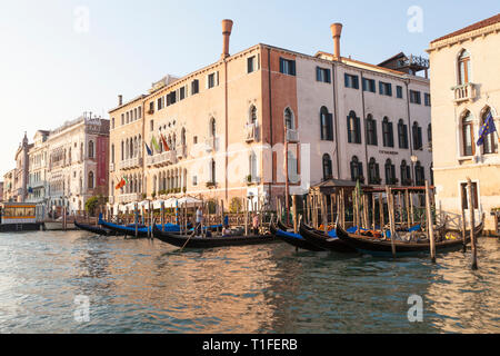 Ca' Sagredo Hotel and gondolas at Campo Santa Sofia, Grand Canal, Cannaregio, Venice, Veneto, Italy at sunset. Ca' d'Oro in background Stock Photo