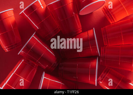 top view of bright and colorful plastic cups on red background Stock Photo