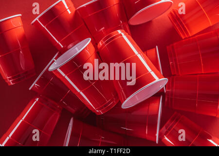 top view of bright and colorful plastic cups on red background Stock Photo