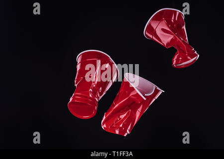 top view of bright and colorful, red plastic cups isolated on black with copy space Stock Photo