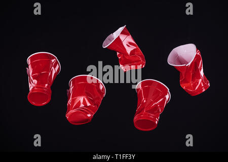 top view of bright and colorful, red plastic cups isolated on black with copy space Stock Photo
