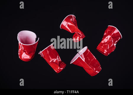 top view of bright and colorful, red plastic cups isolated on black with copy space Stock Photo