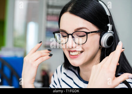 Young beautiful girl with headphones learns language Stock Photo