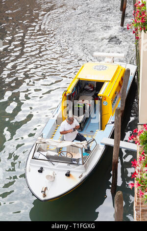 Venetian ambulance waiting in a canal to collect a patient, Venice, Veneto, Italy, looking down from above with staff member in the boat and view to i Stock Photo