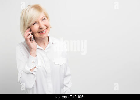 Nice picture of a lady calling t his family using a new smartphone. She adores new technologies and like to try to use new devices as much as she can Stock Photo
