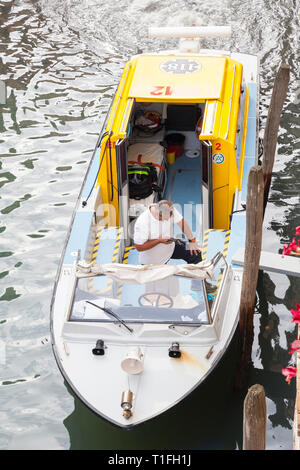 Venetian ambulance waiting in a canal to collect a patient, Venice, Veneto, Italy, looking down from above with staff member in the boat and view to i Stock Photo