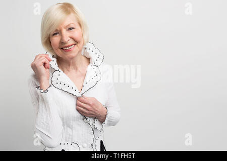 Sunny and beautiful lady is posing to camera. She is showing everybody her good skin on face that glows. The beauty of old age could be like that and Stock Photo