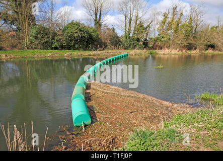 A boom across the River Bure to catch loose floating vegetation upstream of the mill at Horstead, Norfolk, England, United Kingdom, Europe. Stock Photo