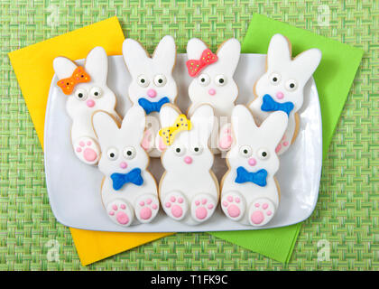 Easter Bunny Sugar Cookies on a plate with green place mat background. Marshmallow fondant covered cookie with candy feet, eyes and nose and tail and  Stock Photo