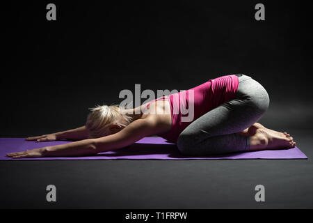 Woman exercising pilates. Child pose yoga. Stock Photo