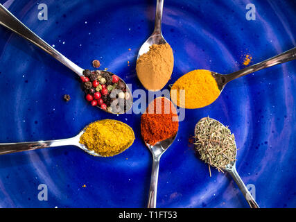 Different colorful spices on dark blue background Stock Photo