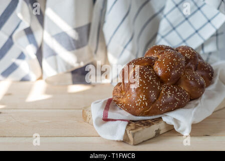 Challah bread on a wood plate on wooden table / white background with copy space Stock Photo