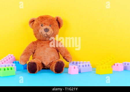 Baby kids toys background with teddy bear and colorful building blocks bricks Stock Photo