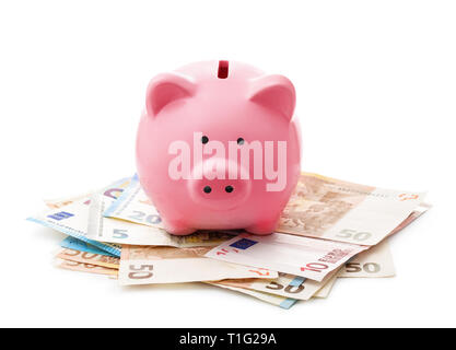 Front view of pink piggy bank on euro banknotes isolated on white Stock Photo