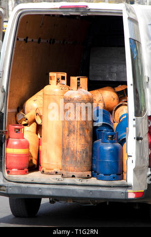 Different color and size cylinder gas bottles in a parked delivery van trunk for refill and supply Stock Photo