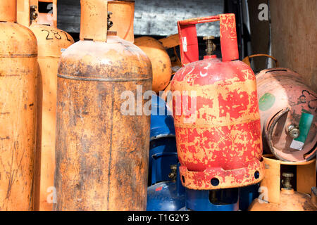 Different color and size cylinder gas bottles stored for refill and supply Stock Photo