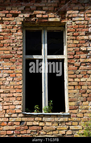 window without glass in an old brick abandoned house Stock Photo