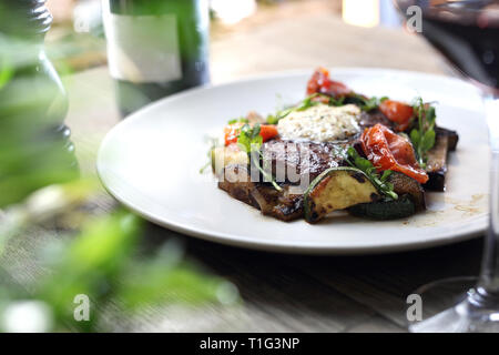 Grilled steak of entrecote with herb butter and grilled vegetables served on a white plate. Stock Photo