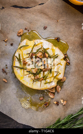 Delicious baked camembert with honey, walnuts, herbs and pears Stock Photo