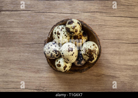Simple Easter flat lay still life with quail eggs on brown wooden background. Stock Photo
