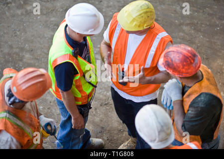 Group of construction workers in safety gear on a construction site. Stock Photo