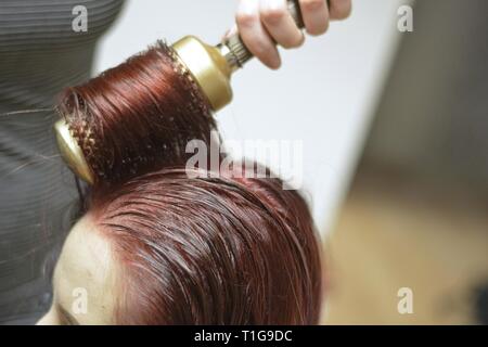 woman blows hair out of hairdryer Stock Photo