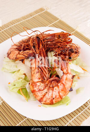 Seared Jumbo prawns with lettuce on restaurant table Stock Photo