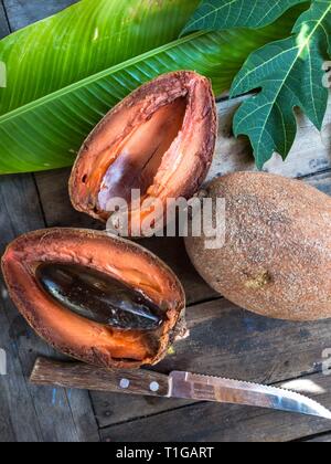 Pouteria sapota, or mamey sapote, cut open on a table in Oaxaca, Mexico Grows in Central America and Cuba. Stock Photo