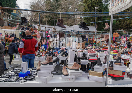 Open air street vendors selling clothes & other merchandise products at stalls every Saturday at a large weekly bazaar flea market in Xanthi, Greece. Stock Photo