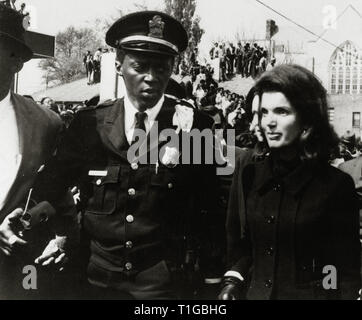 Escorted by an Atlanta policeman, Jacqueline Kennedy arrives at the funeral service for Dr. Martin Luther King Jr. at the Ebenezer Baptist Church, Atlanta, Georgia, (1968)  File Reference # 1003 704THA Stock Photo