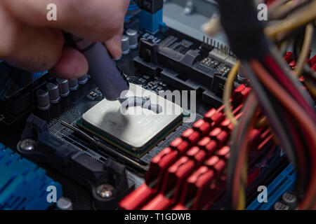 Engineer applying thermal paste on the computer board chip cpu Stock Photo
