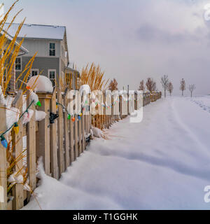 Colorful lights on wooden fence in Daybreak Utah. Colorful lights lining the wooden fence of a home in Daybreak, Utah. Footprints can be seen on the s Stock Photo