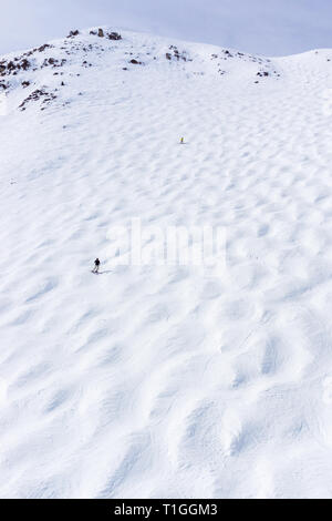 Skiers descending the steep mogul ski hill slope at a mountain in Lake Louise in the Canadian Rockies of Alberta, Canada. Stock Photo