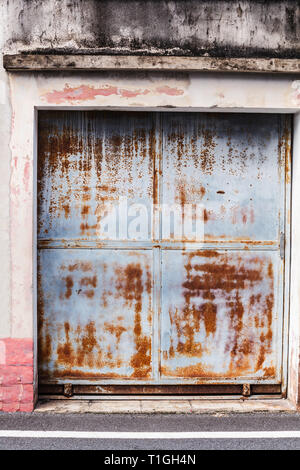 old detailed aged vintage rusty red brown textured zinc alloy metal sheet exterior fence door used in construction industry as warehouse building mate Stock Photo