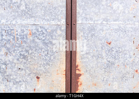old detailed aged vintage rusty red brown textured zinc alloy metal sheet exterior fence door used in construction industry as warehouse building mate Stock Photo