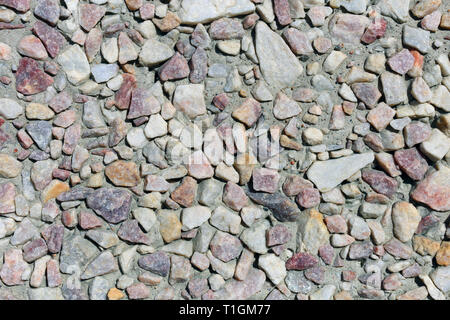 Lovely light colored wall made with colorful pebble stones. Texture of the exterior wall of a building. This photo shows the beautiful architecture. Stock Photo
