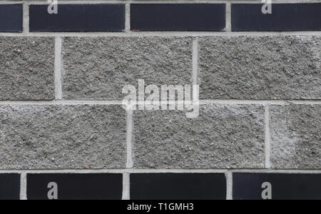 Black and grey brick wall. Texture of the exterior wall of a building. This photo shows the beautiful architectural details of the surface of this wal Stock Photo
