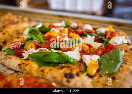 close up of a colourful italian roman style wood fired pizza in a trattoria/pizzeria. Pizza romana Stock Photo
