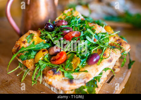 Authentic Italian Roman style vegan pizza slices on a wooden board in a pizzeria Trattoria style restaurant. Italian street food. Selective focus Stock Photo