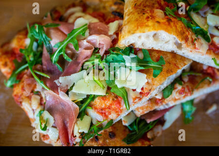 traditional wood fired roman style Italian pizza slices in a pizzeria trattoria restaurant. Pizza romana Stock Photo