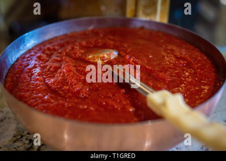 a close up of a bowl of traditional marinara pizza topping tomato sauce in a trattoria/pizzeria Stock Photo