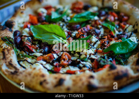 Wood fired pizza. Authentic Italian neapolitan style wood fired pizza on table in a pizzeria trattoria restaurant Stock Photo