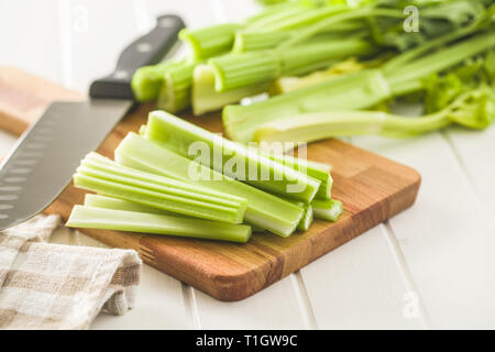 Celery sticks. Cutting celery stalks on cutting board. Stock Photo