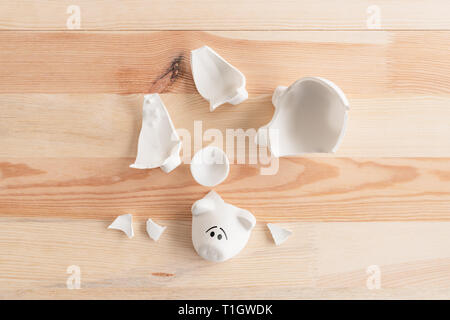 Broken piggy coin bank on the table, top view with no money in saving funds Stock Photo