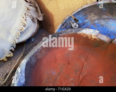 Wooden round dishes with paint of red and blue on yellow background. Stock Photo