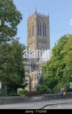 Lincoln Cathedral alternate viewpoint between trees, Northgate outside Lincoln Hotel. Lord Alfred Tennyson statue in garden. Famous Yellowbelly, Stock Photo