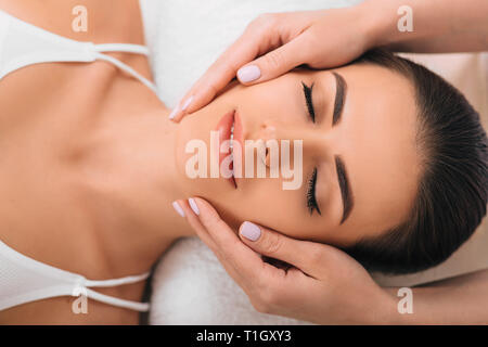Close up of a beautiful woman receiving facial massage Stock Photo