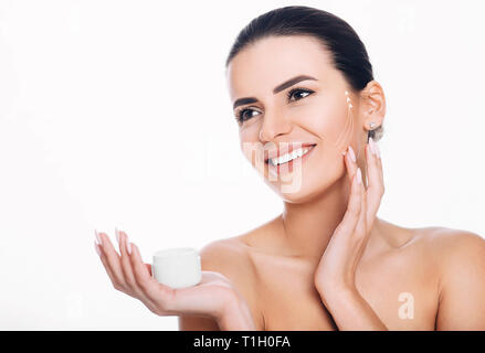 smiling woman with lifting arrows on face applying moisturizer on skin. Concept of moisturizer skin lifting Stock Photo