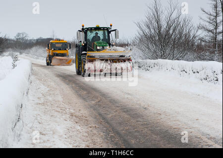 vehicles clearing snow from road in rural location on Dartmoor Stock Photo