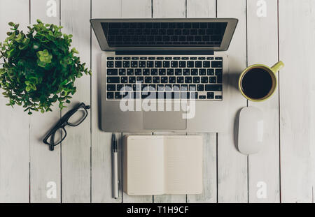 Laptop on Vintage Wooden desktop in modern office with accessories Stock Photo